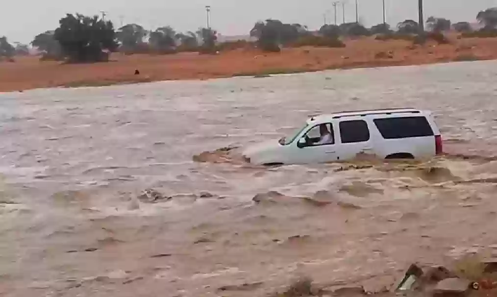 شاب يغامر بقفزة في سيل جارف في المدينة